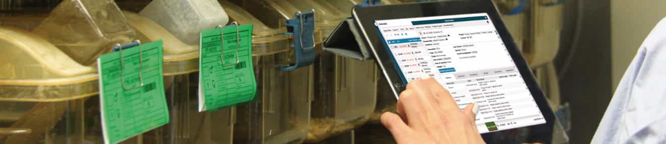 A person using a tablet in front of an animal rack